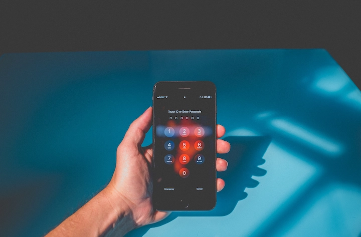 Hand holding a smartphone on login screen